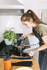 Femme fait cuire des pâtes pour économiser l'eau