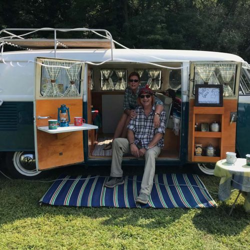 Vanlife, couple heureux, dans volkswagen vintage aménagé pour voyage autonome avec toilettes sèches
